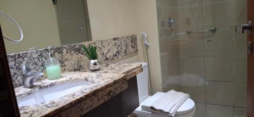 a bathroom with a sink and a shower and a toilet at Um lar aconchegante na rota do sol in Natal