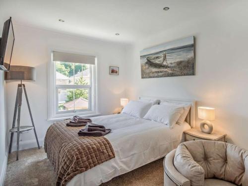a bedroom with a bed and a chair and a window at 3 Bed in Shanklin oc-92052 in Shanklin