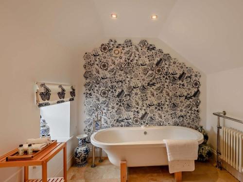 a bath tub in a bathroom with a black and white wall at 3 Bed in Morpeth oc-61257 in Harbottle