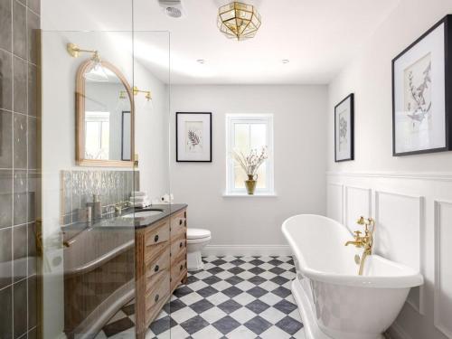 a bathroom with a sink and a tub and a toilet at 5 Bed in Lymington oc-96189 in Sway