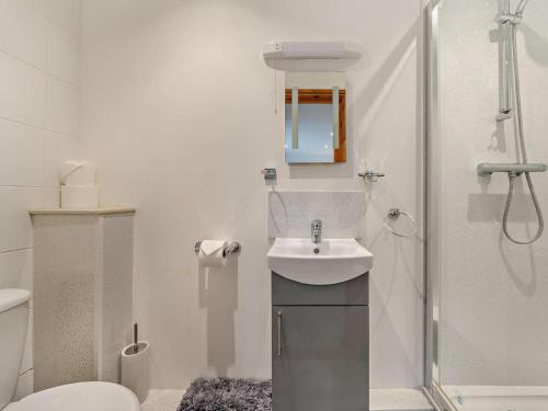 a white bathroom with a sink and a shower at 3 Bed in Wareham oc-dc157 in Stoborough