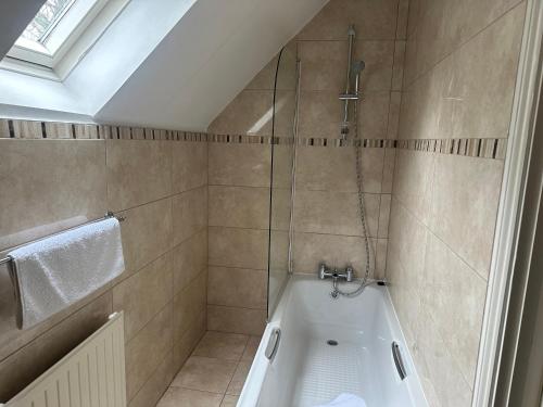 a bathroom with a shower and a bath tub at Heritage Grange at Thurston, Hotel in Bury Saint Edmunds