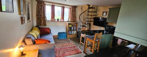 a small living room with a couch and a table at Pellcroft Cottage in Holmfirth