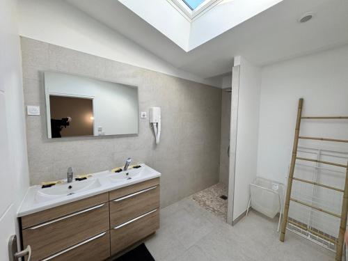 a bathroom with a sink and a mirror on the wall at VILLA Papillon , maison entière avec jardin in Champigny-sur-Marne