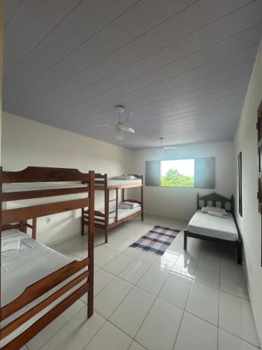 a room with two bunk beds and a table at Pousada Maia in Itaúnas