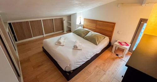 a bedroom with a bed with a pair of shoes on it at Duplex moderne au Palais des Papes in Avignon