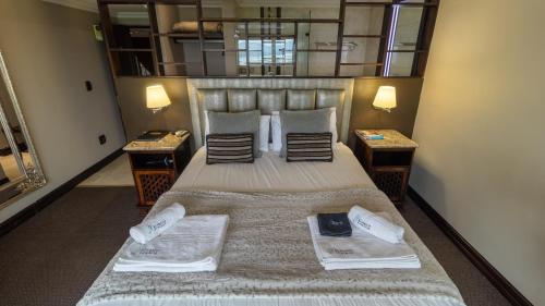 a bedroom with a large bed with two night stands at Kosmos Lodge in Hartbeespoort