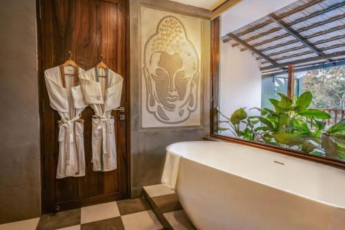 a bathroom with a large bath tub and a window at Anantya At Anamiva in North goa