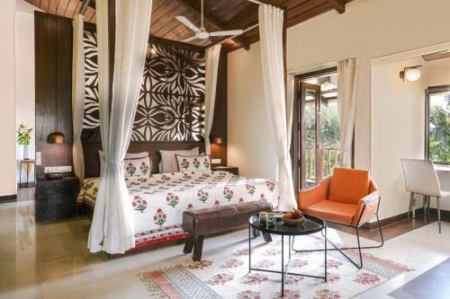 a bedroom with a bed and a table and a chair at Anantya At Anamiva in North goa