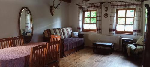 a living room with a couch and a chair and windows at Budafai Vendégház in Kiscsehi