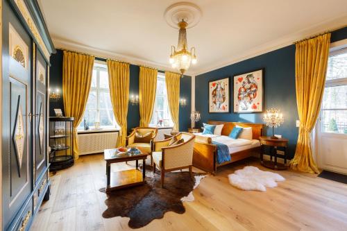 a bedroom with a bed and a living room at Hotel Design Villa Ottilienruh in Ilsenburg