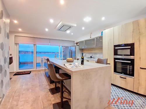 a kitchen with a large island with a counter top at Seafront Apt Mellieha with Stunning Sea Views in Is-Sellum
