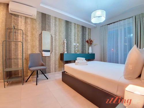 a bedroom with a bed and a chair and a mirror at Seafront Apt Mellieha with Stunning Sea Views in Is-Sellum