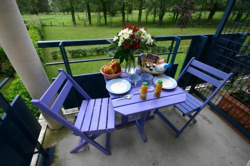 a purple table with two chairs and a vase of flowers at Residence Hotel Les Ducs De Chevreuse avec Hébergement, Repas & PDJ, Séminaire, Bureau & Parking in Chevreuse