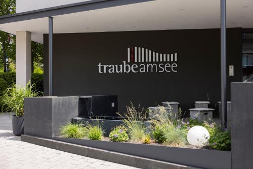 a sign on the side of a building with plants at Hotel Traube am See in Friedrichshafen
