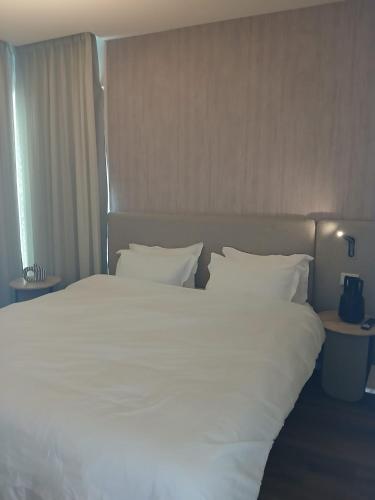 a large white bed with white sheets and pillows at Amor Club Luxury Suite in Eilat