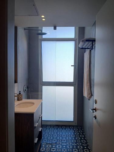 a bathroom with a shower and a sink and a door at Amor Club Luxury Suite in Eilat