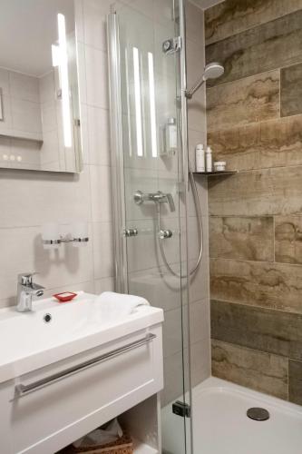 a bathroom with a shower and a white sink at Doppelzimmer 18 in Heidenheim