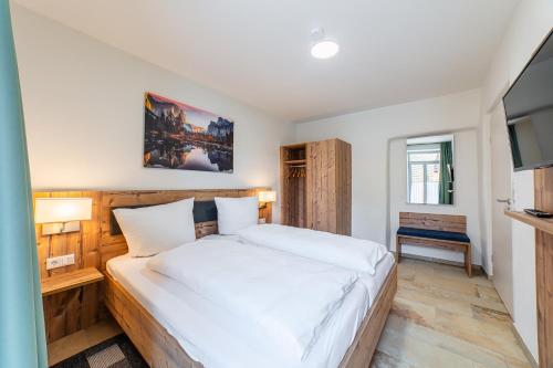 a bedroom with a large bed and a television at Apartment mit Terrasse "Traumhopfen" in Spalt