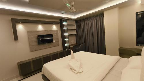a hospital room with a bed and a tv at Hotel High Rise in Kolkata