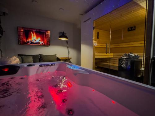 a room with a hot tub with a fireplace at Day SPA Design Muhr in Wehlenberg