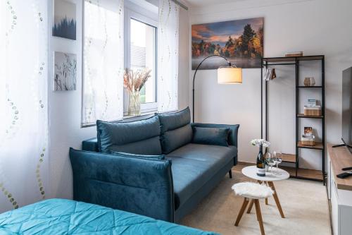 a living room with a blue couch and a table at Skandi Streudorf in Muhr amSee