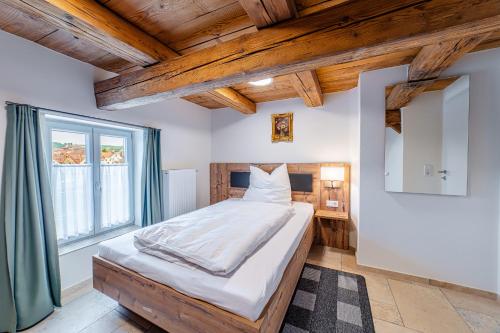 a bedroom with a large bed in a room with wooden ceilings at Wellness Apartment Suite "Paradies Suite" in Spalt