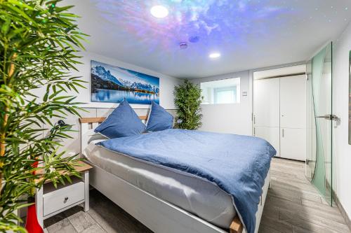 a bedroom with a bed with a blue comforter at Day SPA Streudorf in Muhr amSee