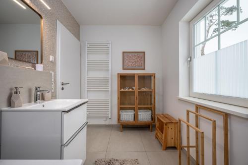 a white bathroom with a sink and a window at Schwedenhaus Leevsteed in Neuhaus