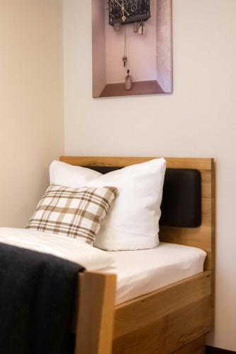 a bed with two pillows on top of it at Einzelzimmer 9 in Heidenheim