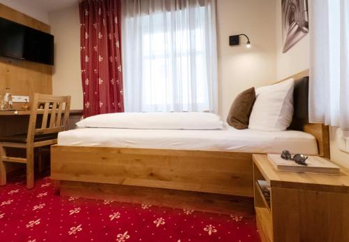 a bedroom with a bed with a window and a desk at Einzelzimmer 16 in Heidenheim