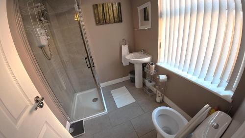 a bathroom with a shower and a toilet and a sink at Modern 1 Bedroom Apartment Free Parking WiFi Near City Centre in Leeds