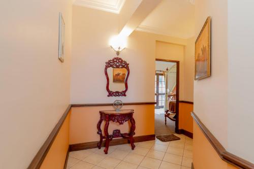 a hallway with a table and a mirror at Ard Lui Residence in Nuwara Eliya