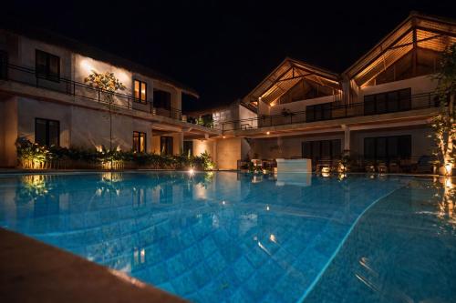 a swimming pool in front of a building at night at Bella Vida Resort, Uluwatu in Uluwatu