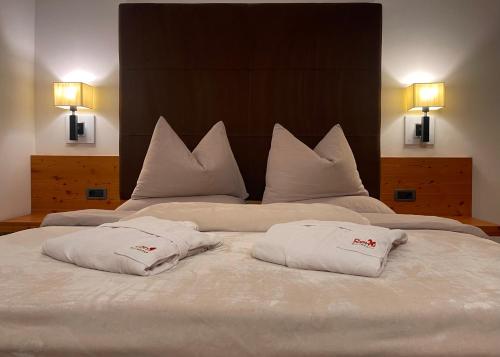 a large white bed with two white pillows on it at Residence Remi in Senales