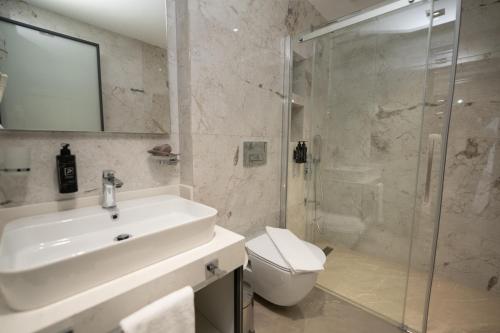 a bathroom with a sink and a shower and a toilet at Sunset Luxury Apartments in Keramoti