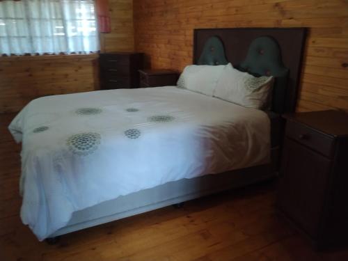 a bedroom with a white bed with a wooden floor at 41onLeo in Eersbewoond