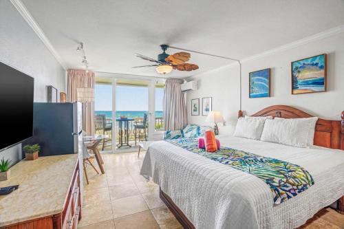 a bedroom with a bed and a view of the ocean at Islander on the Beach 249 in Kapaa