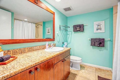 a bathroom with a sink and a toilet and a mirror at Islander on the Beach 249 in Kapaa