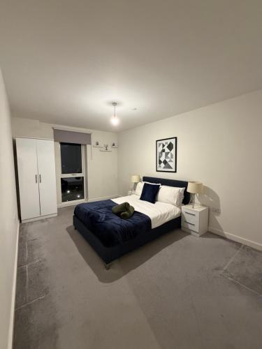 a bedroom with a large bed with a blue blanket at Prestige London Apartment Balcony Views in London