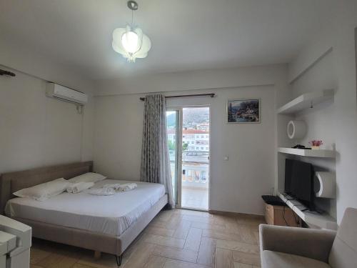 a bedroom with a bed and a sliding glass door at Saranda Promenade Studio Apartment in Sarandë