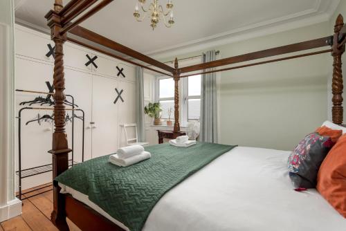 a bedroom with a canopy bed with towels on it at Double Edinburgh Homestay in Edinburgh