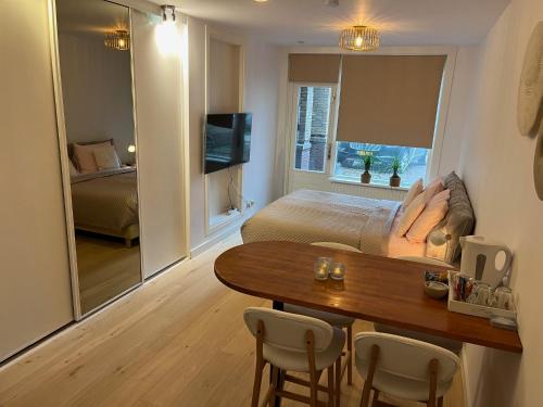 a living room with a bed and a table and chairs at Quarles 80 - free parking in Noordwijk aan Zee