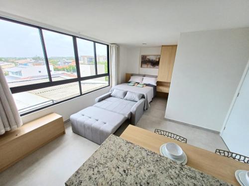 a living room with two couches and a large window at Flat em Tamandaré - 102 - Carneiros Beach Exclusive in Tamandaré
