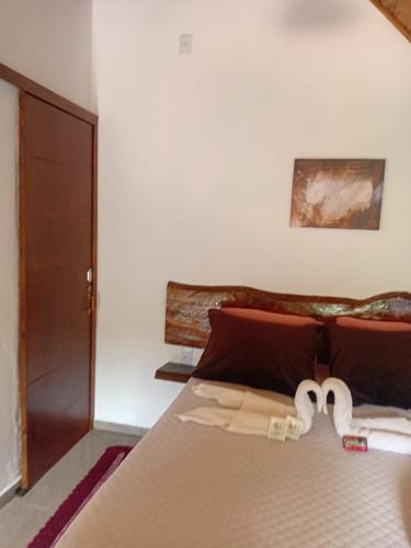 a bedroom with a bed with two towels on it at Chalé 2 com hidromassagem in Camanducaia