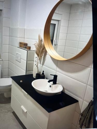 a bathroom with a sink and a mirror at Ferienwohnung Benz in Löningen