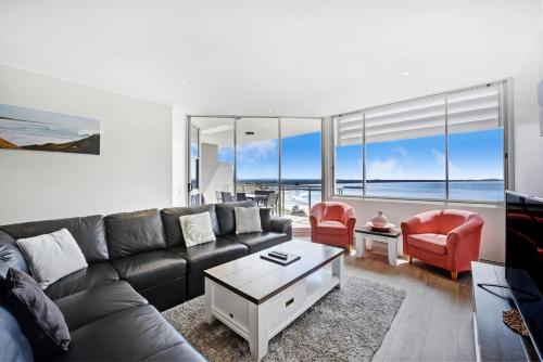a living room filled with furniture and a large window at Sandcastle Apartments in Port Macquarie