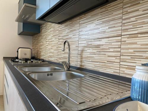 a kitchen with two sinks and a brick wall at Giotera Village in Sciacca