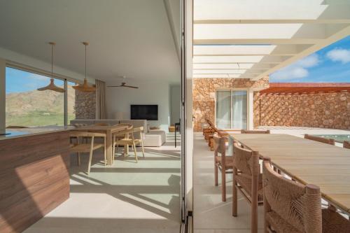 an open kitchen and dining room with wooden tables and chairs at Villa Gypsy by Aura Collection in Tindaya