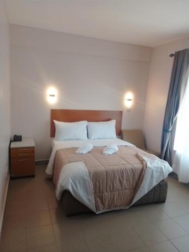 ein Schlafzimmer mit einem großen Bett und zwei Kissen in der Unterkunft Atlas Hotel in Arusha